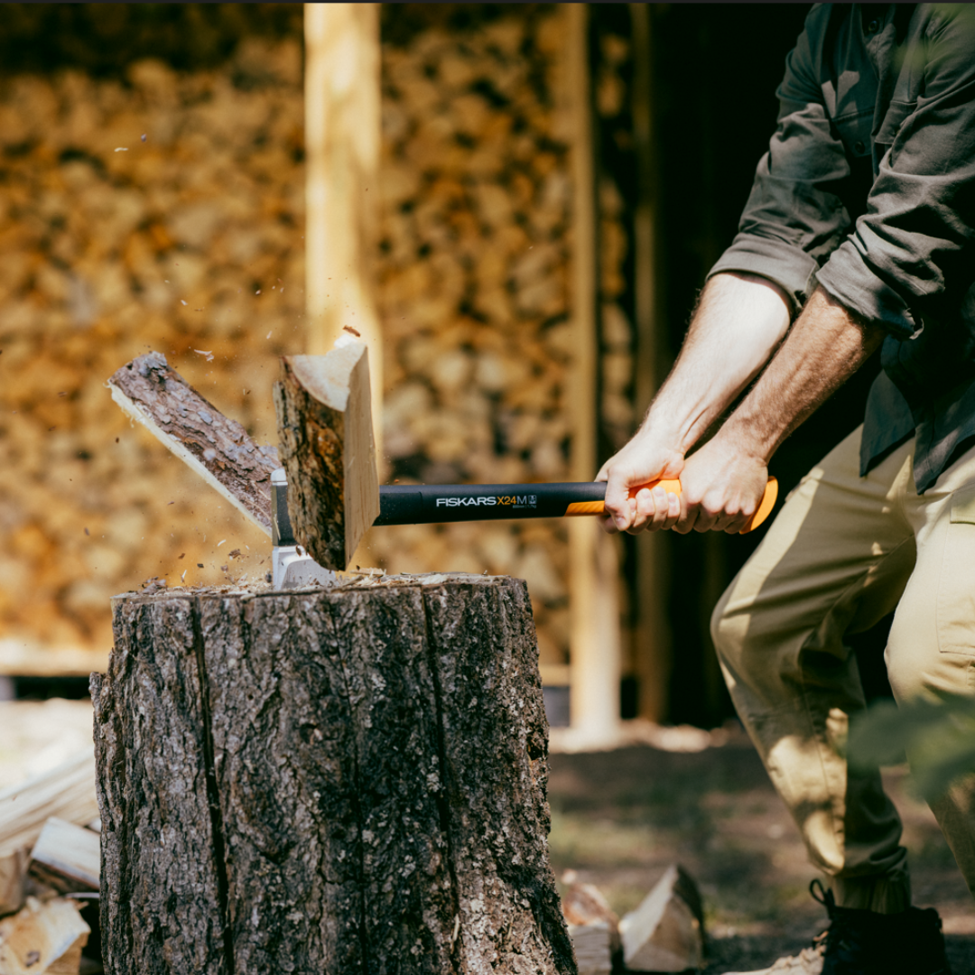axe tool splitting wood log outdoors demonstrating power of Fiskars splitting axe
