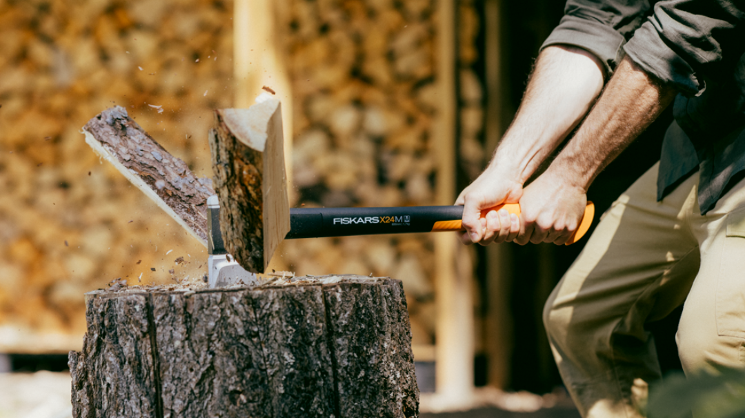 axe tool splitting wood log outdoors demonstrating power of Fiskars splitting axe