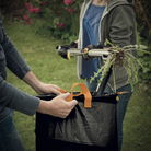 Two people with gardening tools and plants in a garden setting
